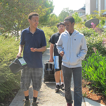 Teen boys carrying composting containers