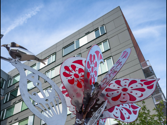 Residential building with sculpture in front of it