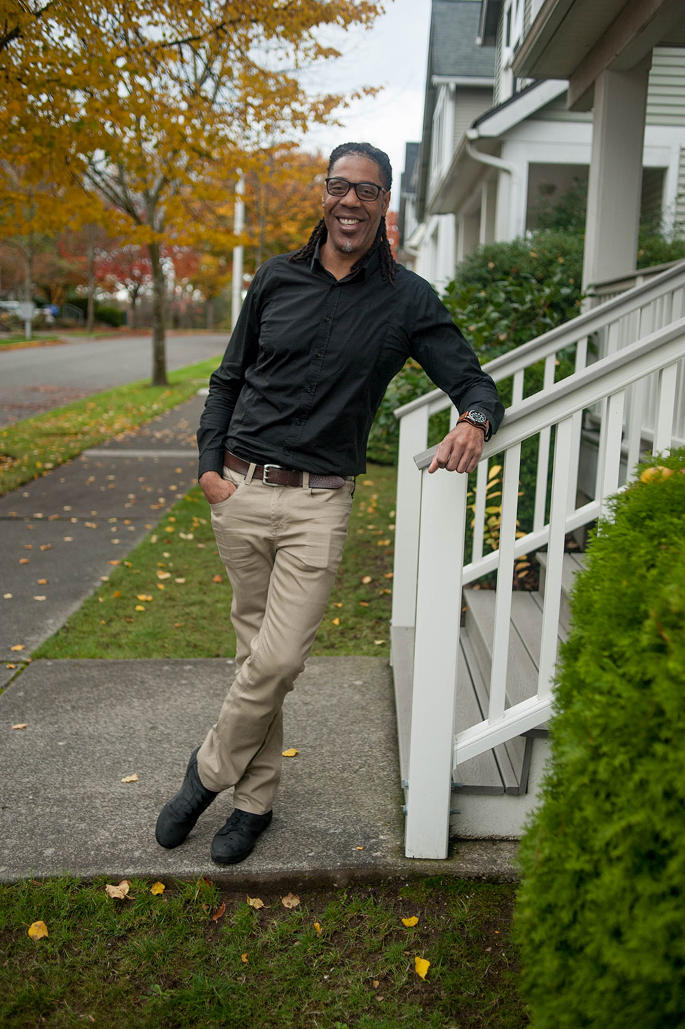 Man leaning on stair railing near house