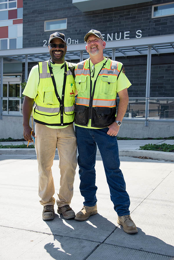 Two men in construction gear standing together at work site