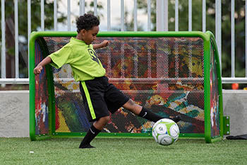 boy kicking socker ball