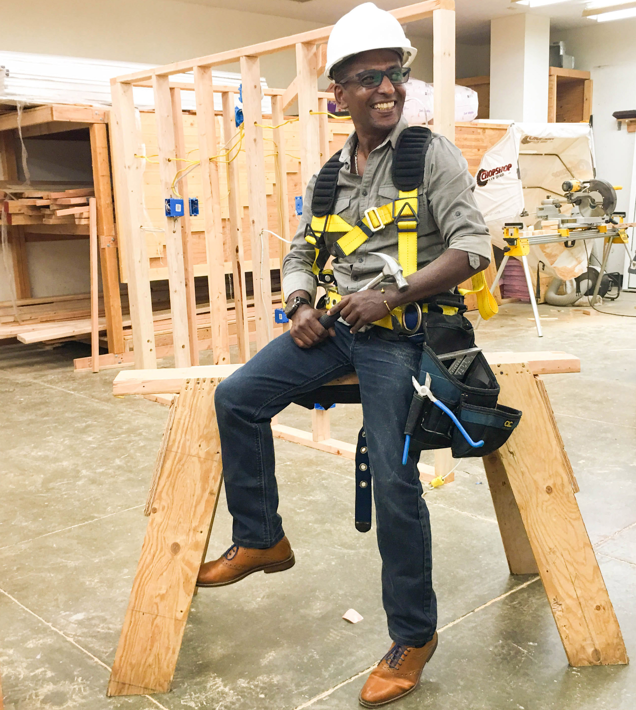 Man is construction gear seated on a saw horse