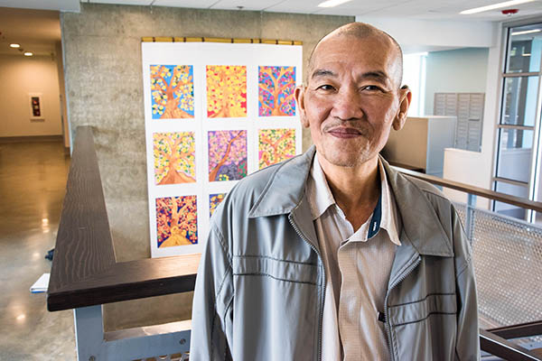 Man standing in front of art displayed in a building