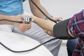 Health care worker taking blood pressure