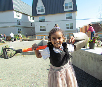 Girl holding shovel in garden