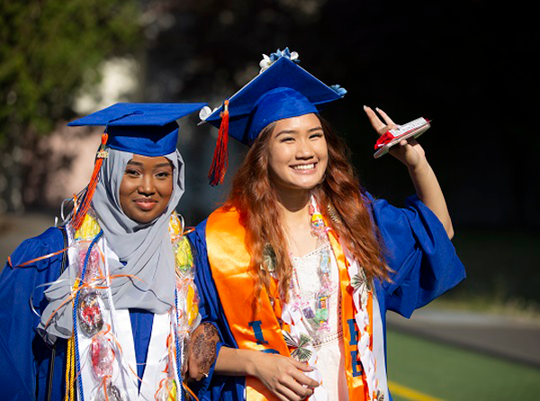 Two young women graduates in caps and gowns