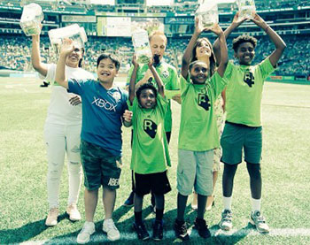 Children hold up their goal post designs at halt-time of Sounders FC game