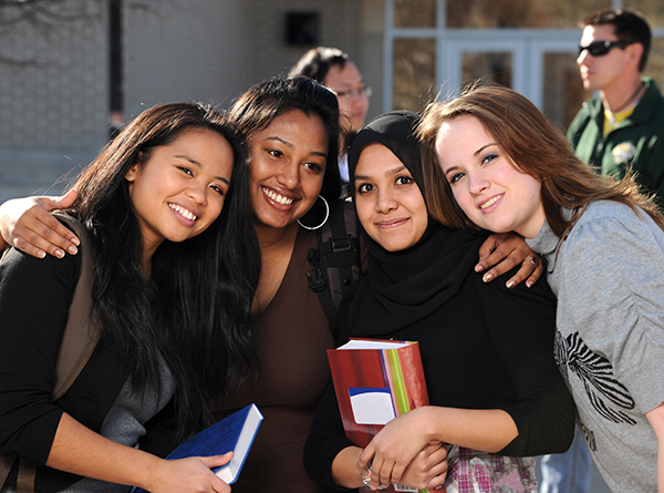 Teen girls standing together holding books