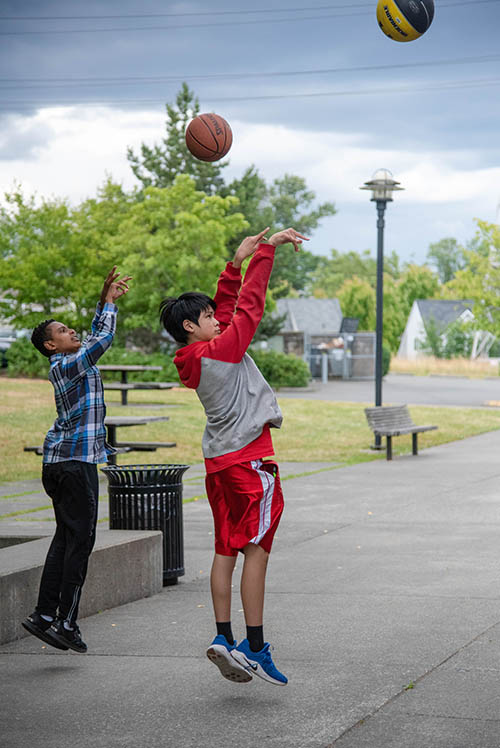 Two boys throw basketballs