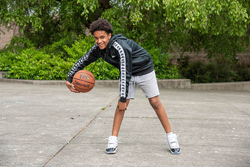 Boy plays with basketball