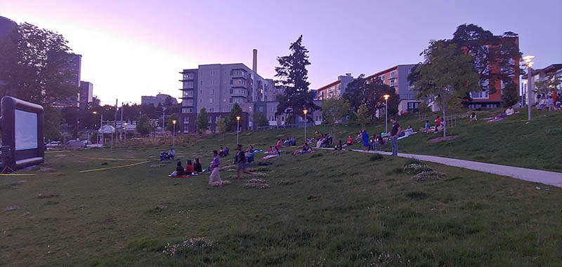 People viewing movie on outdoor screen in park