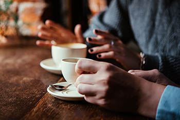 hands holding coffee cups