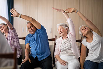 senior citizens exercising in chairs
