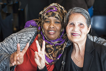 Two smiling women sitting next to each other