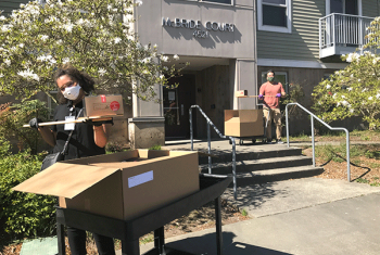 Two SHA staff members delivering meals to residental building