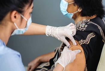 Nurse giving elderly woman a vaccine