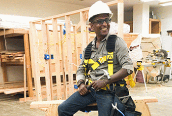 Man in construction gear seated on a saw horse