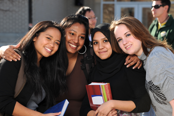 Teen girls standing together holding books