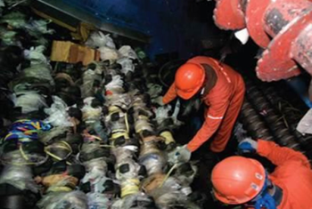 Men in hard hats and protective gear showing recycling garbage plastic bags