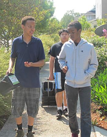 Teen boys carrying composting containers