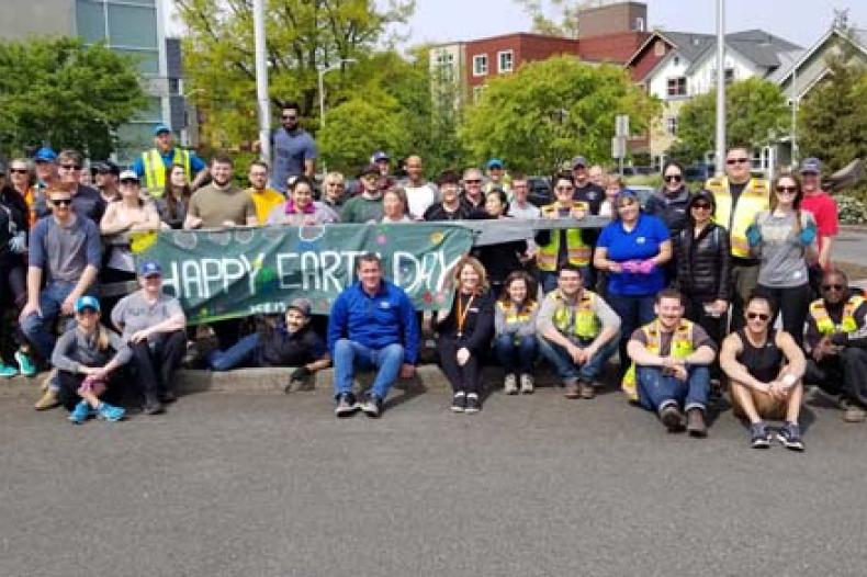 Group of people sitting in front of 'Happy Earth Day' banner