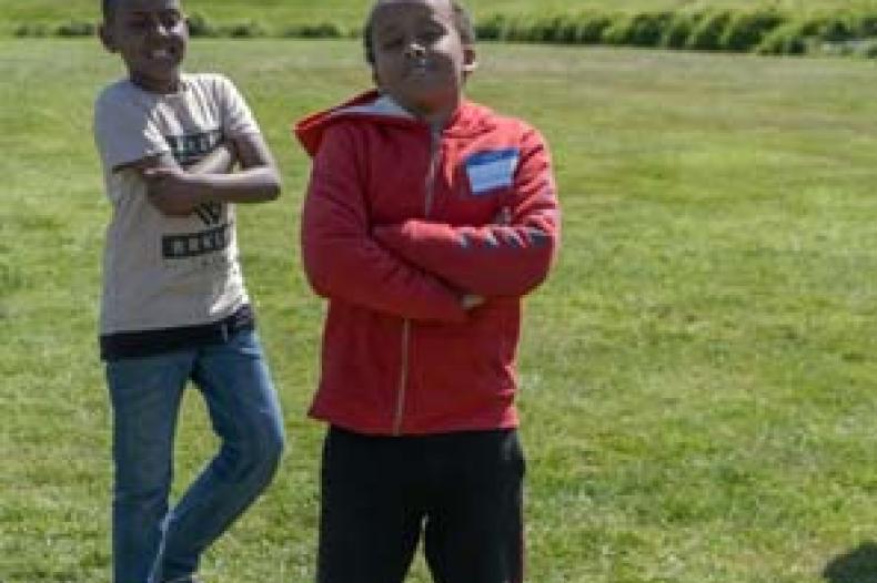 Boys standing with their arms folded on field