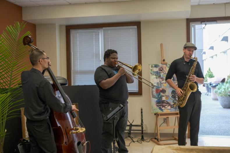 Three musicians playing bass, trumpet and saxophone