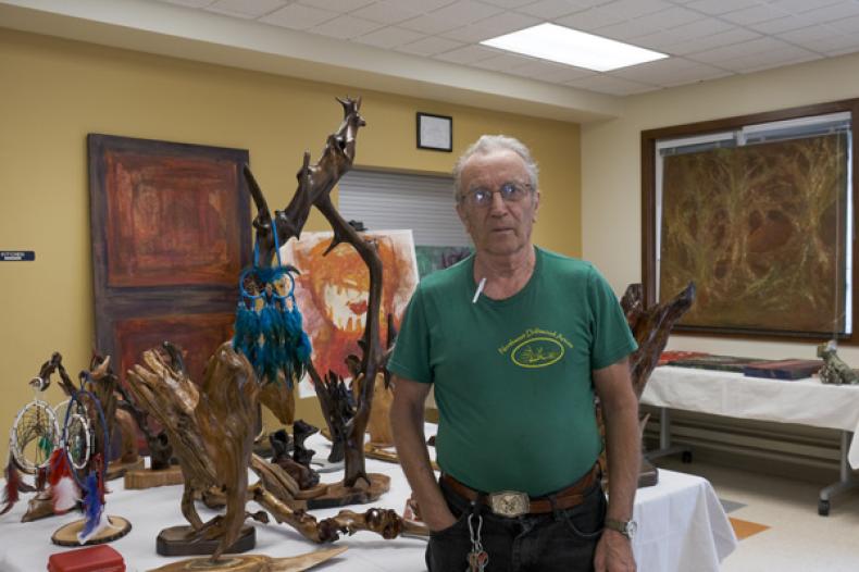Man stands next to art sculptures on a table