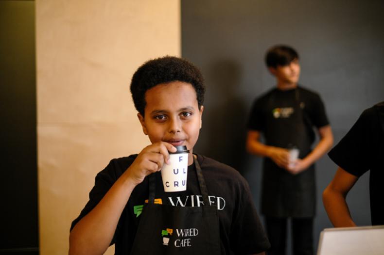 Teenage boy sips coffee 