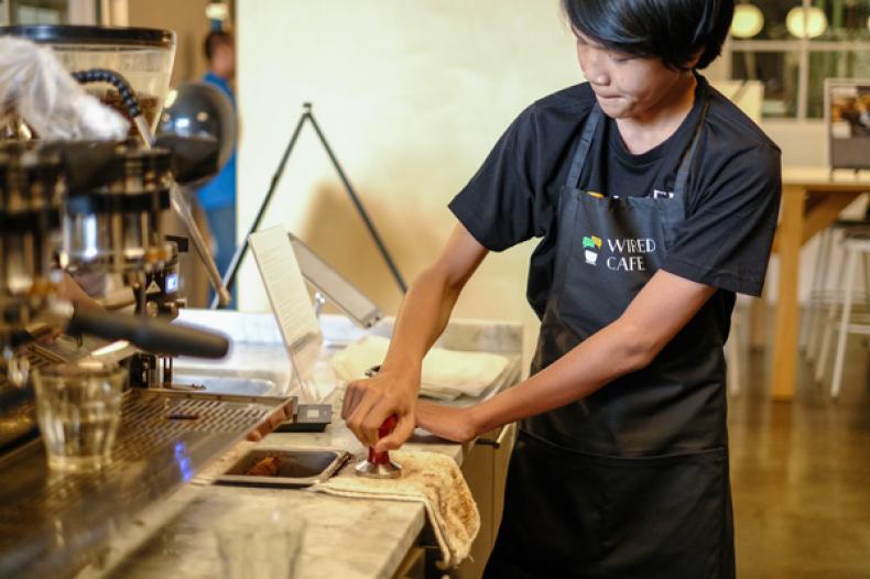Youth cleans out a coffee filter