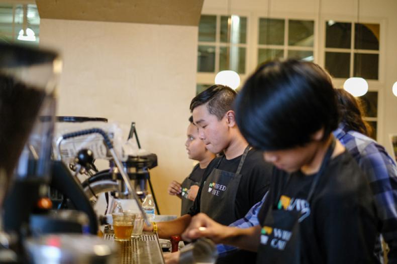 Row of youth preparing coffee 