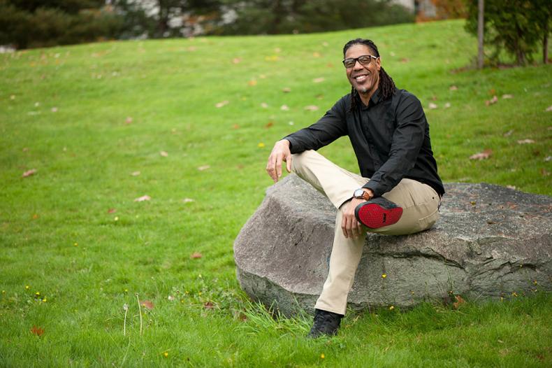Smiling man sitting on rock