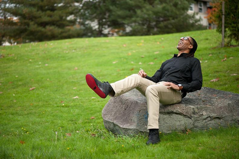 Man leaning back on rock and laughing