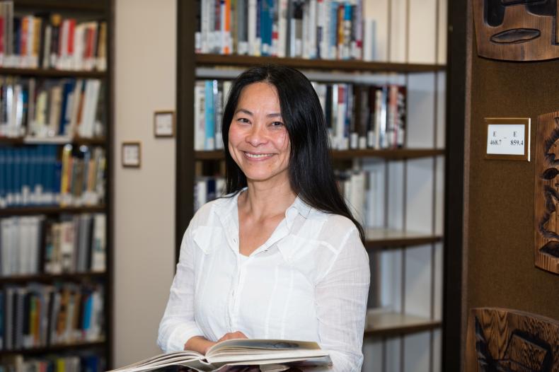 Woman holding an open book in a library