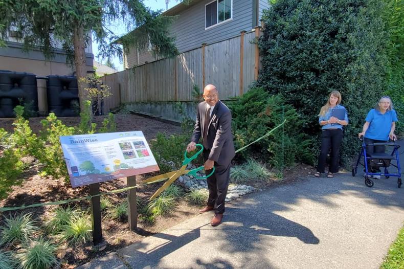Ribbon cutting in front of apartment building to launch environmental program