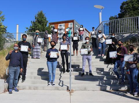 Group of teens holding up certificates for completing course