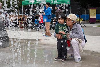 Woman and boy watch fountain in spray park