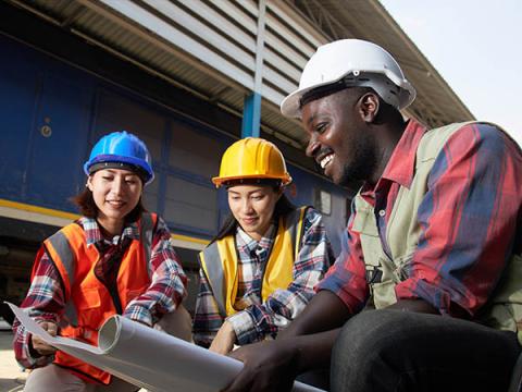 Two women and a man at a construction site