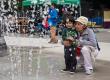 Woman and boy watch fountain in spray park