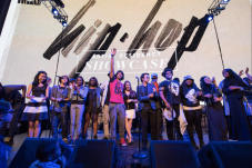 Young people standing on stage with the words "hip hop" in the background