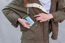 Woman putting face mask in pocket
