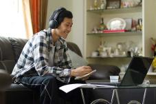 Young man talking with laptop in front of him