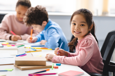 Image of child smiling sitting in a classroom