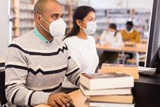 People sitting in library with face masks on