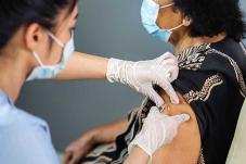 Nurse giving elderly woman a vaccine
