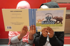 Image of two children holding a book titled "Geel & Marood"