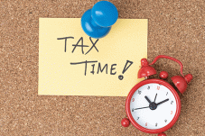 'Tax Time!' written on yellow sticky with a clock next to it