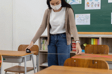 Teacher measuring distance between desks 