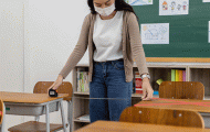 Teacher measuring distance between desks 