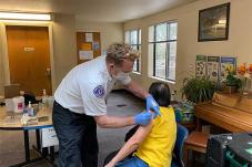 Member of Seattle Fire Department gives a person a vaccine 